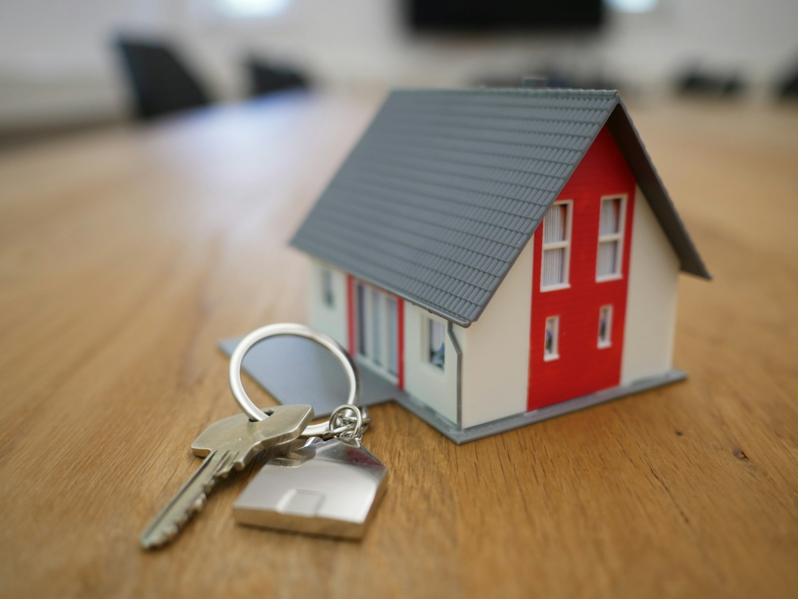 House model with keys representing the decision to rent or buy a home